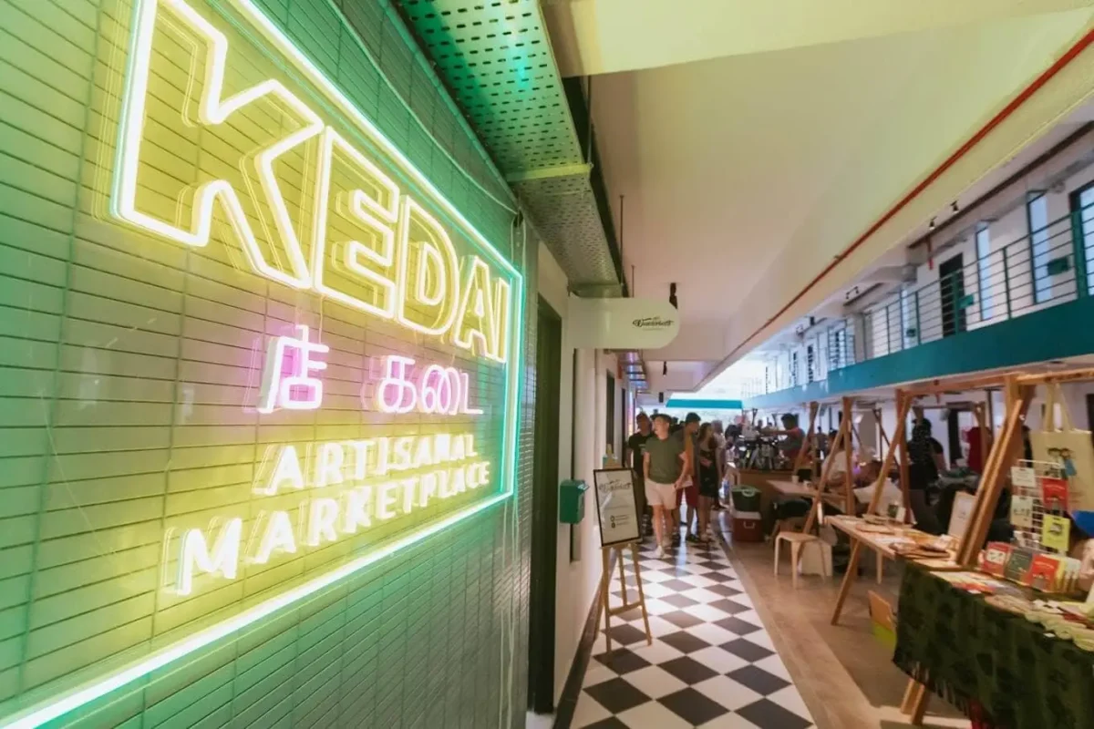 Vibrant Kedai KL Artisanal Marketplace entrance featuring neon signage and a bustling artisan market.